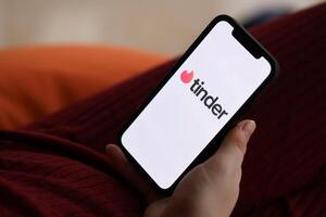 KYIV, UKRAINE - FEBRUARY 23, 2024 Tinder logo of famous dating website or app on iPhone display photo