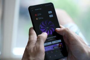 KYIV, UKRAINE - APRIL 20, 2024 Tronix App telegram bot on smartphone screen. Tronix App is a viral Telegram based crypto game for earn TRX tokens by managing virtual crypto exchange photo