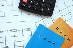 Japanese pension insurance booklets on table with calculator on table photo