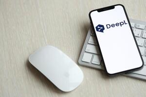 KYIV, UKRAINE - MARCH 17, 2024 DeepL logo on iPhone display screen with apple keyboard and mouse on table photo