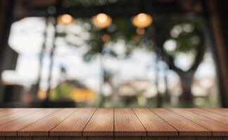 Empty wooden table top with lights bokeh on blur restaurant background. photo