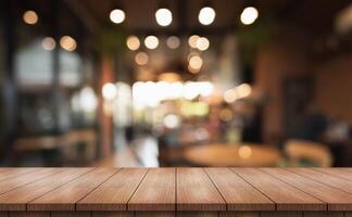 Empty wooden table top with lights bokeh on blur restaurant background. photo