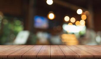Empty wooden table top with lights bokeh on blur restaurant background. photo