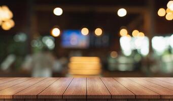 Empty wooden table top with lights bokeh on blur restaurant background. photo