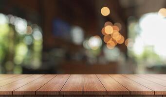 Empty wooden table top with lights bokeh on blur restaurant background. photo