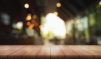Empty wooden table top with lights bokeh on blur restaurant background. photo