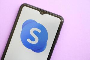KYIV, UKRAINE - APRIL 1, 2024 Skype icon on smartphone screen on purple table photo