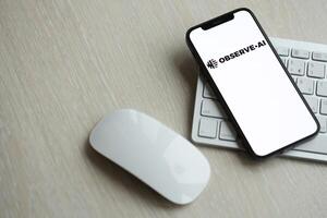 KYIV, UKRAINE - MARCH 17, 2024 ObserveAI logo on iPhone display screen with apple keyboard and mouse on table photo