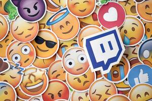 KYIV, UKRAINE - APRIL 20, 2024 Twitch logo and large set of stickers with Emoji yellow faces. Emoji is a pictogram or smiley embedded in text and used in electronic messages photo