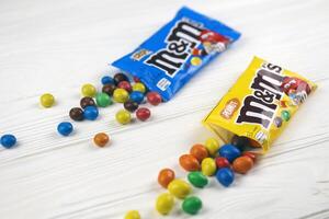 KHARKIV, UKRAINE - JANUARY 2, 2021 M and Ms colorful button shaped chocolate candies. Multi colored chocolates each of which has the letter m printed in lower case in white photo