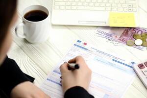 KYIV, UKRAINE - OCTOBER 31, 2023 Accountant fill french tax form 10963 Value added tax and similar taxes in end of tax period. Taxation and paperwork routine photo