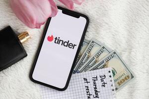 KYIV, UKRAINE - FEBRUARY 23, 2024 Tinder logo of famous dating website or app on iPhone display photo