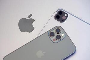 KYIV, UKRAINE - 4 MAY, 2023 Apple brand devices iphone and ipad lies on macbook body photo