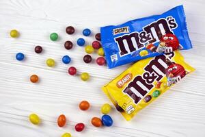 KHARKIV, UKRAINE - JANUARY 2, 2021 M and Ms colorful button shaped chocolate candies. Multi colored chocolates each of which has the letter m printed in lower case in white photo