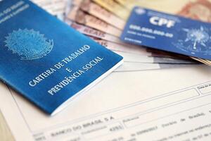 TERNOPIL, UKRAINE - JULY 7, 2023 Brazilian Work Permit document and Brazilian tax number card on table with tax form photo