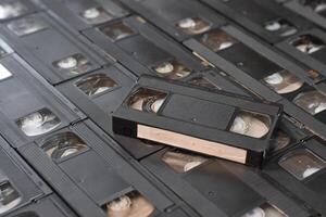 KYIV, UKRAINE - 4 MAY, 2023 tape on colored background, VHS, cassette. Messy stack of VHS tapes. Home System tape photo