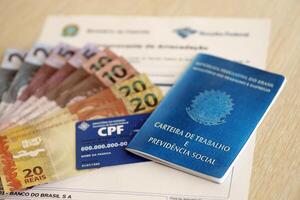 TERNOPIL, UKRAINE - JULY 7, 2023 Brazilian Work Permit document and Brazilian tax number card on table with tax form photo