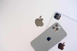 KYIV, UKRAINE - 4 MAY, 2023 Apple brand devices iphone and ipad lies on macbook body photo
