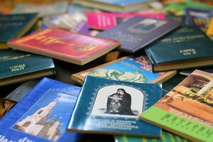 KYIV, UKRAINE - 4 MAY, 2023 Christian slavonic religious book stacked on table in chaotic order photo