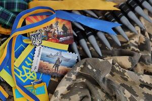 KYIV, UKRAINE - 4 MAY, 2023 Ukrainian attributes and souvenirs on green pixel camouflage photo
