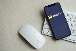 KYIV, UKRAINE - MARCH 17, 2024 Murf AI logo on iPhone display screen with apple keyboard and mouse on table photo