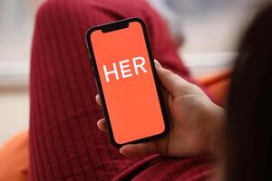 KYIV, UKRAINE - FEBRUARY 23, 2024 Her logo of famous dating website or app on iPhone display photo