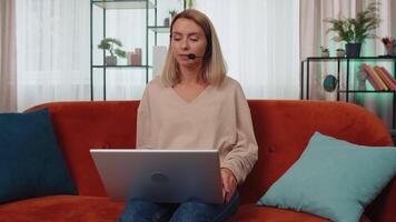 jovem mulher freelance trabalhador ligar Apoio, suporte Centro serviço operador linha de apoio tendo conversa com cliente video