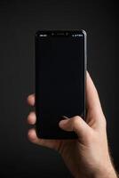 Close-up of a person's hand holding a smartphone photo