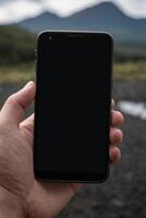 Close-up of a person's hand holding a smartphone photo