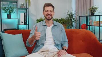Happy young man looking approvingly at camera showing thumbs up, like positive sign, good news video