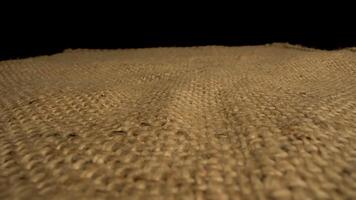 This features a close up view of the texture of burlap fabric. The camera slowly pans across the surface, revealing the intricate woven pattern of the natural fibers. video