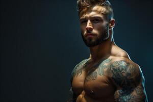 Muscular handsome bodybuilder posing with tattoos against a dark background, copy space photo