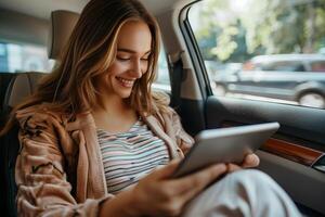 Young woman using tablet in backseat of car during daytime commute photo