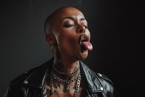 Close up portrait of a woman with a shaved head and multiple piercings sticking her tongue out photo