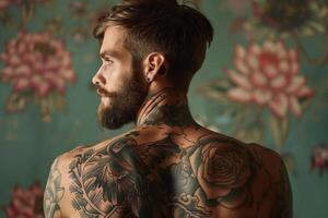 Man with tattoos in front of floral wall photo