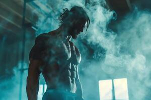 A muscular bodybuilder poses in a smoky gym, showcasing his defined physique. The blue-tinted lighting and thick smoke create a dramatic atmosphere, emphasizing the mans strength and determination photo