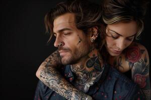 Tattooed couple posing closely against a black background photo