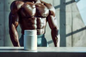 Muscular athlete stands before supplement container in gym. Sports nutrition jar layout photo