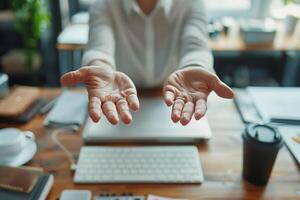 Person holding out open hands at desk with computer keyboard, women's empty palms photo