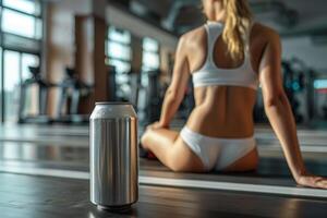 Aluminum can resting on treadmill in gym with woman sitting in background photo