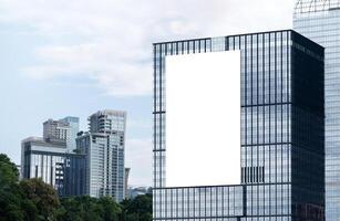 Mock up white vertical large LED display billboard on tower building with blue sky background .clipping path for mockup photo