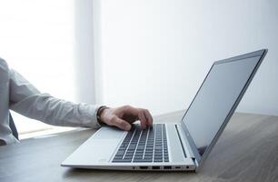 Business man hands typing on laptop computer keyboard, surfing the internet at the office with copy space for web banner, IT worker and business concept photo
