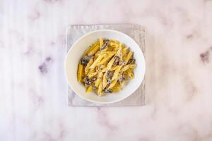 Penne Truffle mushrrom pasta served in dish isolated on grey background top view of italian fastfood photo