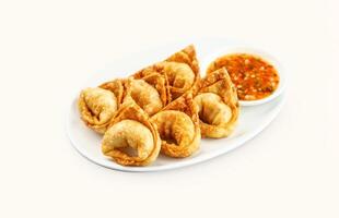 profundo frito crujiente camarón y Cerdo wontons con chile salsa servido en plato aislado en gris antecedentes lado ver de hong kong comida foto
