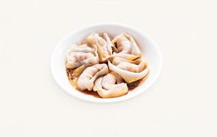 Dumplings, Wontons, Shao Mai, Shrimp and Pork Wontons with spicy Sauce served in plate isolated on grey background side view of hong kong food photo