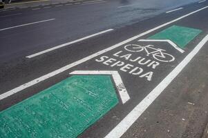 a bicycle way or bike lane on the side of an asphalt road in the city of Surabaya photo