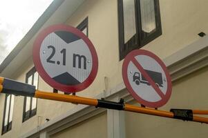 a sign about the height limit for vehicles permitted to pass and a sign that trucks are prohibited from passing photo