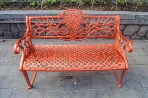 A red wrought iron park bench. photo