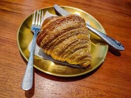a plate of croissant bread served on a wooden table in a luxury cafe or restaurant photo