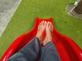 point of view of a girl who is sliding down a slide at a playground photo